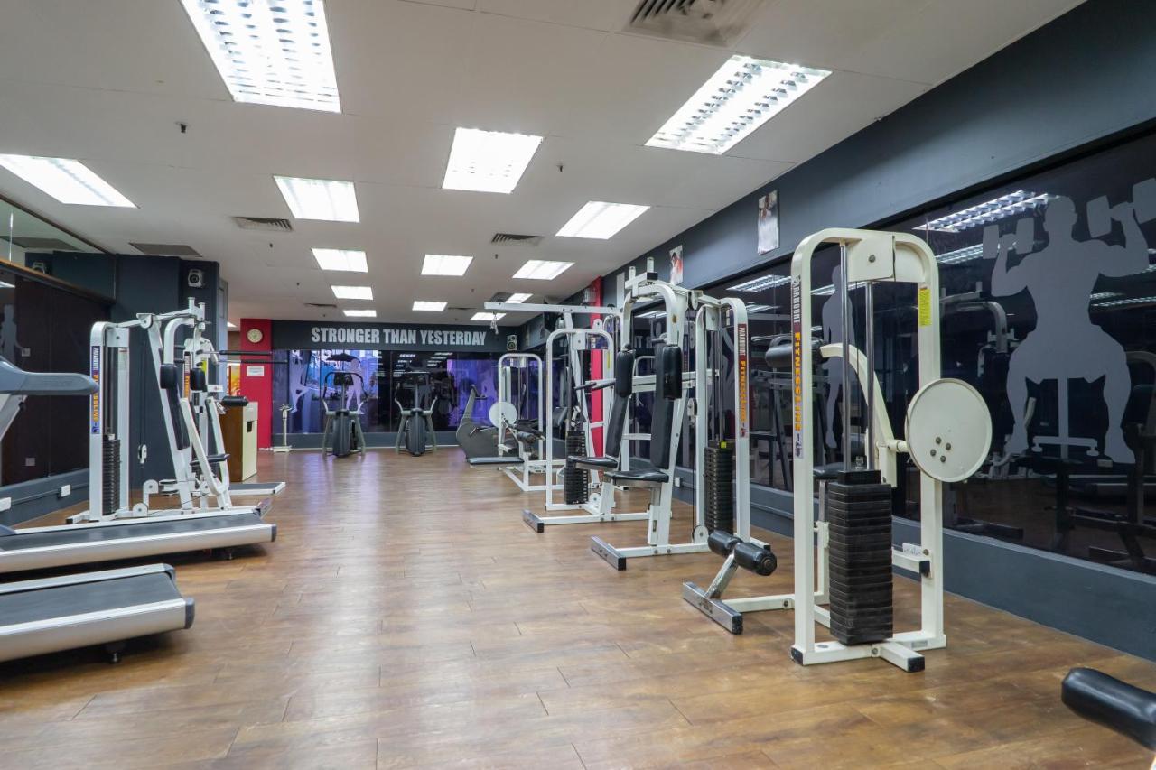 Seri Pacific Hotel Kuala Lumpur Exterior photo The photo shows an empty gym interior equipped with various exercise machines. The floor is made of wood, and the lighting is bright, coming from ceiling fixtures. On one wall, there is a motivational message that reads "Stronger Than Yesterday." The