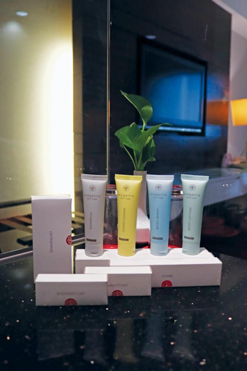 Seri Pacific Hotel Kuala Lumpur Exterior photo The photo shows a display of several small tubes of products, likely skincare or beauty items, arranged in a row on a shelf. The tubes are in different colors: one is white, another is yellow, and the other two are light green and blue. Behind the tu