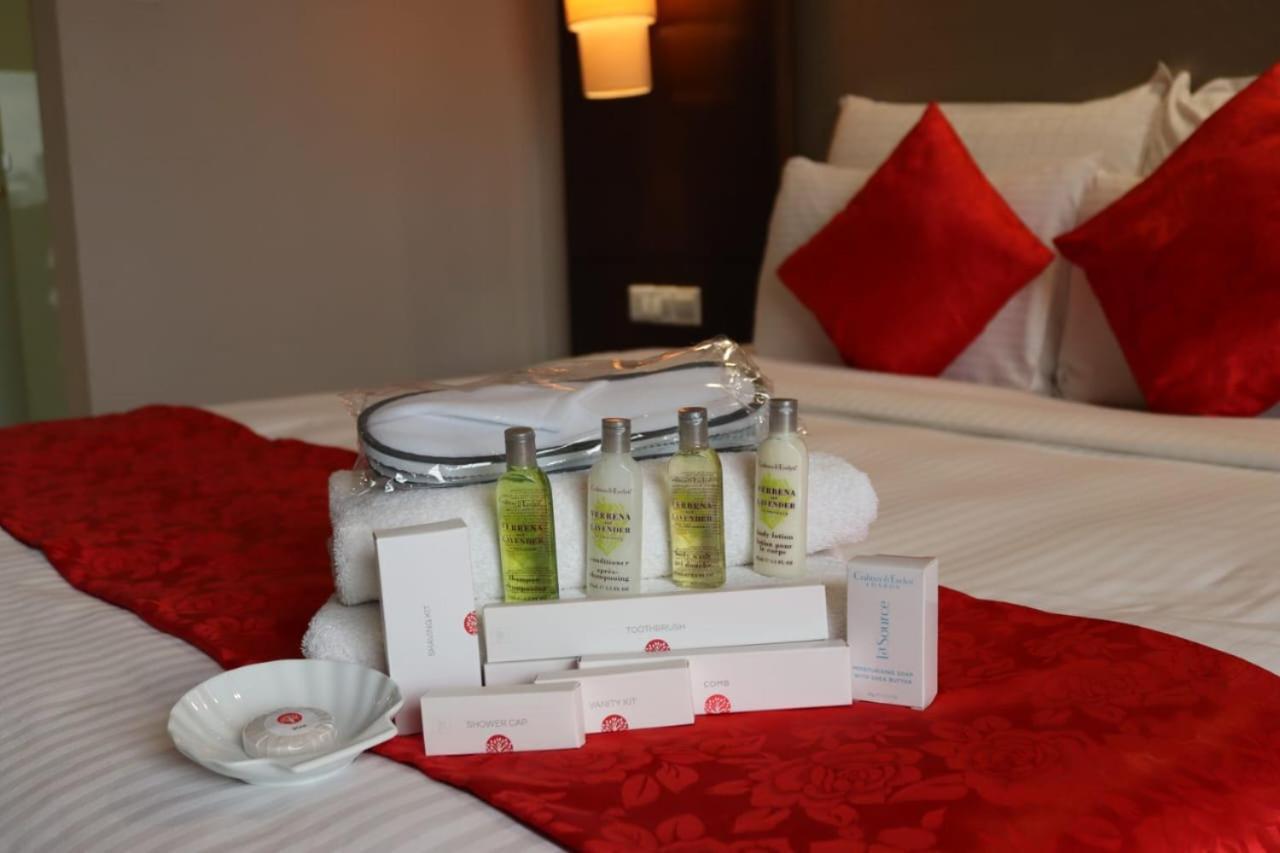 Seri Pacific Hotel Kuala Lumpur Exterior photo The photo shows a neatly arranged display on a bed. In the center, there is a set of four small bottles of toiletries, likely including various lotions or shampoos. These are accompanied by a white dish and two boxes, suggesting they may contain addi